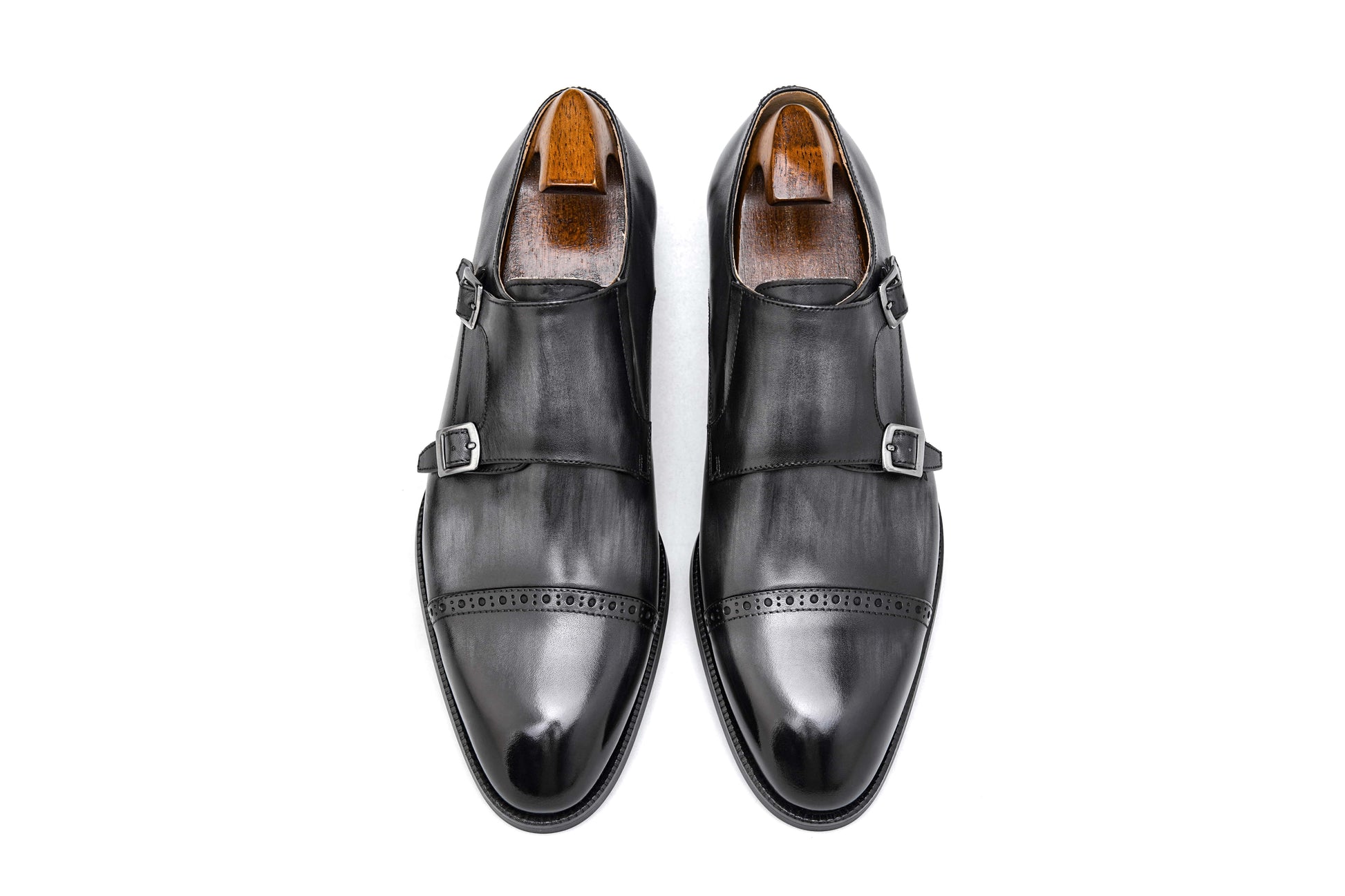 Polished Black Double Monk Strap Leather Shoes – pair with shoe trees, top-down view, showcasing high-gloss full-grain leather and cap-toe broguing.