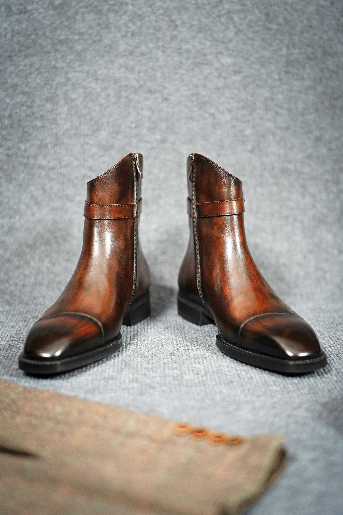 Premium Brown Leather Ankle Boots for Urban Adventures – a straight-on shot of the pair of boots on a gray textured background, highlighting the sleek silhouette.