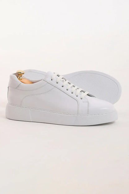 Pristine Luxe White Leather Sneakers - Luxury Comfort for Every Occasion – side view of one shoe with the other in the background, highlighting the durable rubber sole and a minimalist design.