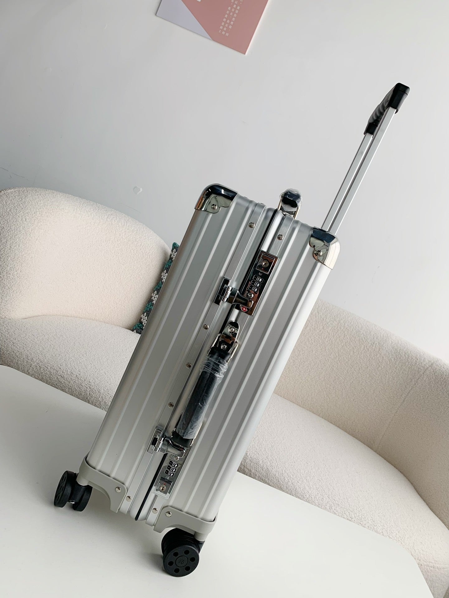 Silver suitcase on a white surface with a light gray background