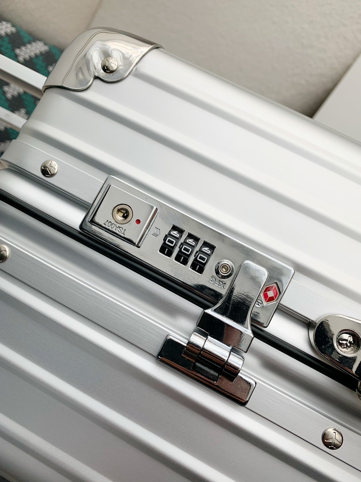 Close-up of a silver suitcase with a lock mechanism