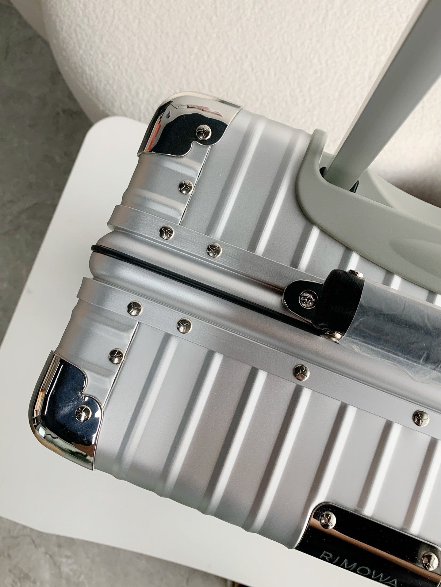 Silver suitcase with visible brand name on a light background