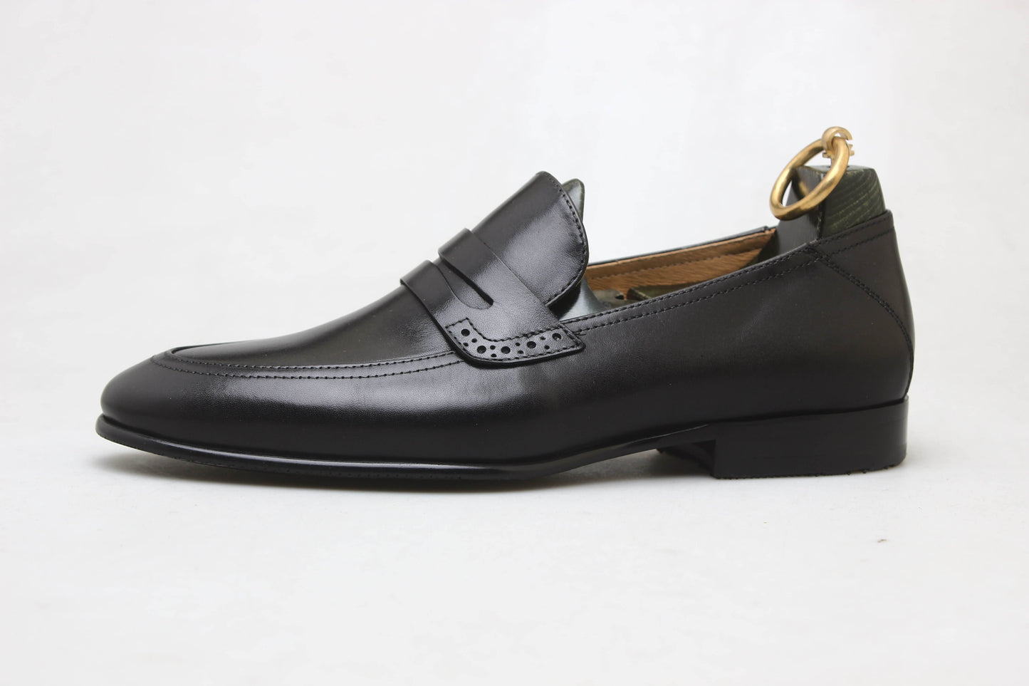 Refined Black Leather Penny Loafer – side view with shoe tree on white background, highlighting premium leather and sleek silhouette for versatile wear.