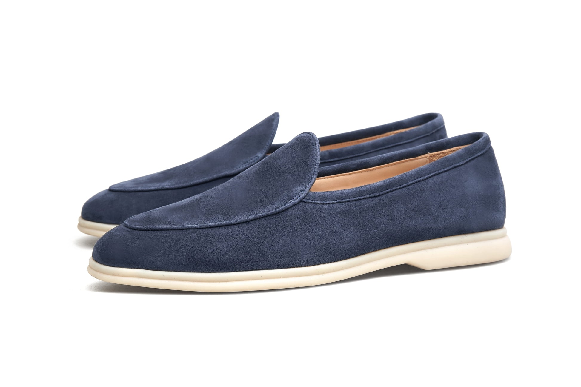Pair of navy blue suede Venetian loafers on white background, front view