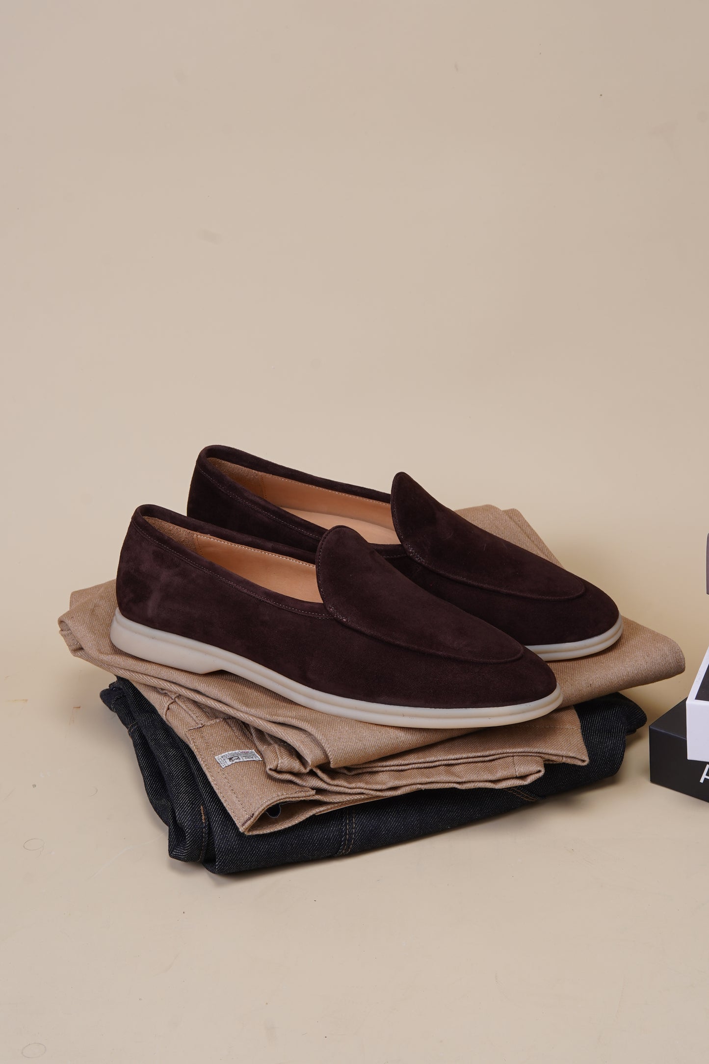 Pair of Siena coffee-brown suede Venetian loafers styled on neutral background, top view