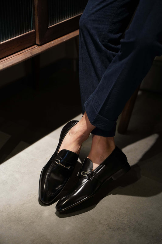 Sophisticated Black Leather Bit Loafers For Men – worn by a man in navy cuffed trousers, showcasing sleek silhouette and a polished finish.