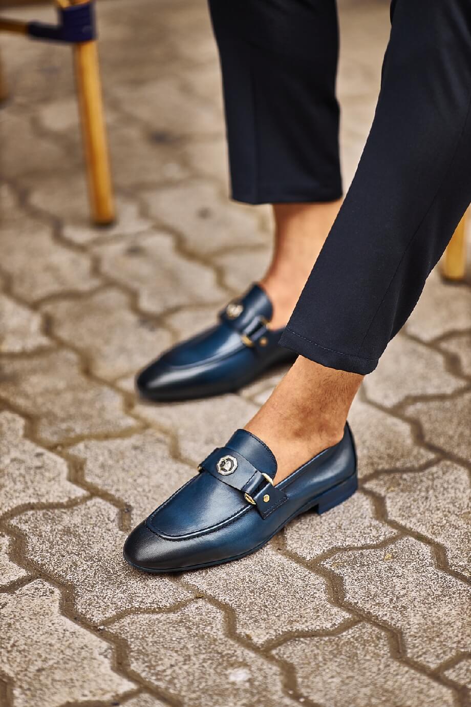 Sophisticated Navy Blue Leather Penny Loafer - Elegance Redefined – close-up on foot, highlighting high-quality leather, a sleek metal buckle, and a navy blue finish.
