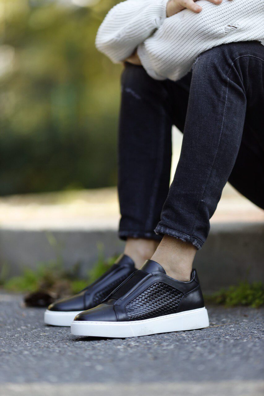 Special Design Black Straw Detail Leather Sneakers – worn by a man in distressed black jeans, sitting on stairs, highlighting a unique straw detail and comfortable fit.