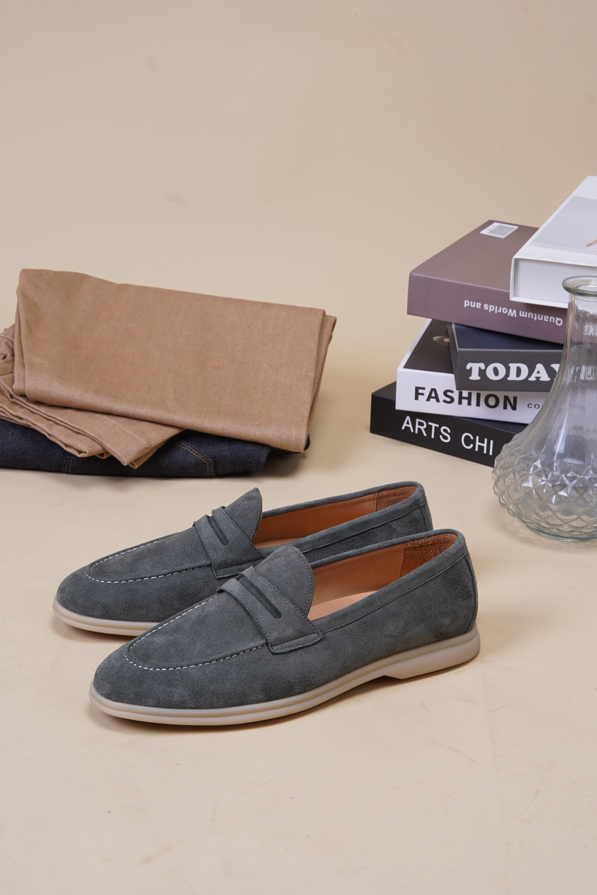 Amalfi pale cyan suede penny loafers with penny keeper strap on neutral surface, angled pair