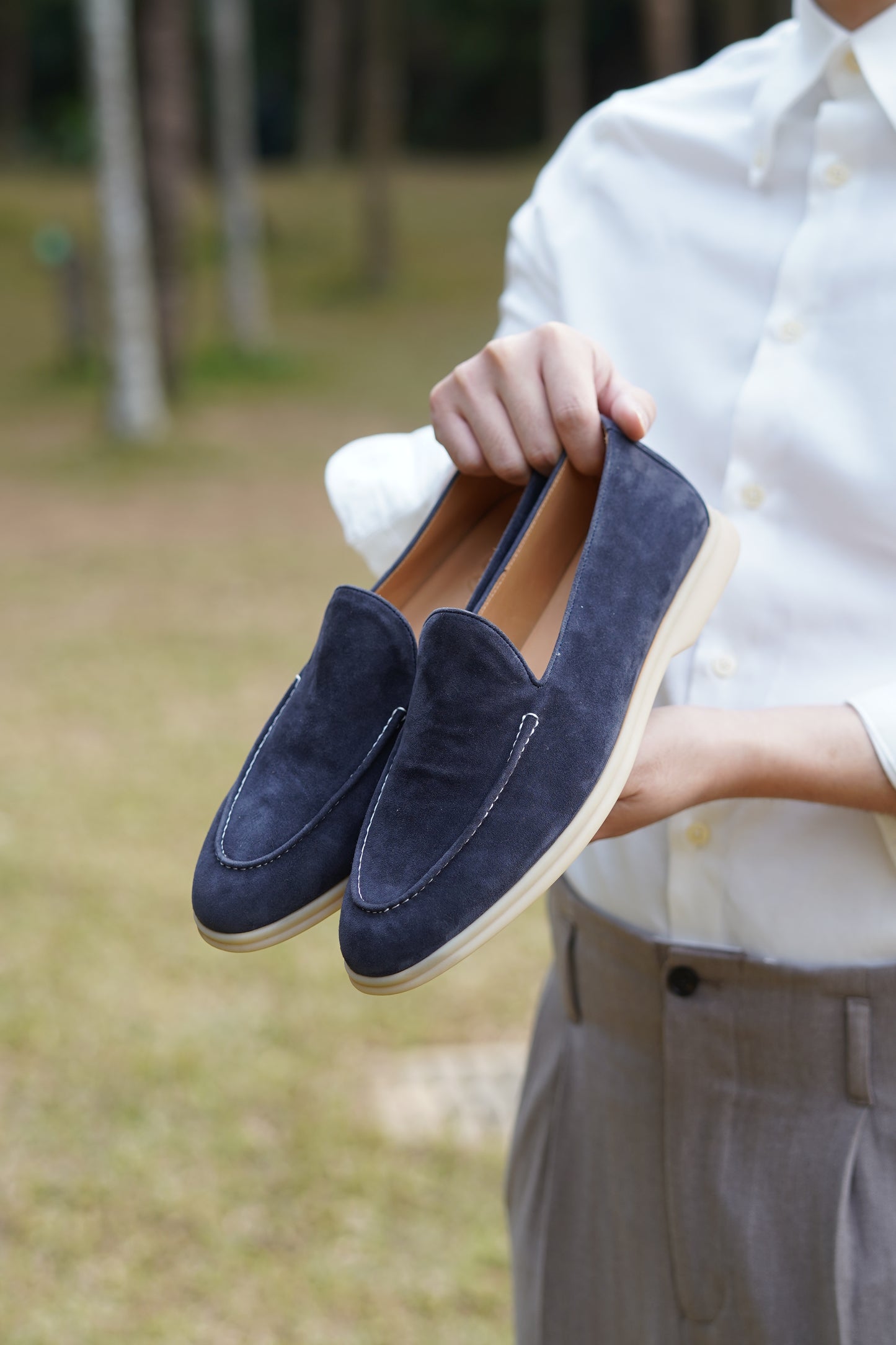 Como deep navy suede penny loafers worn outdoors, on-foot view