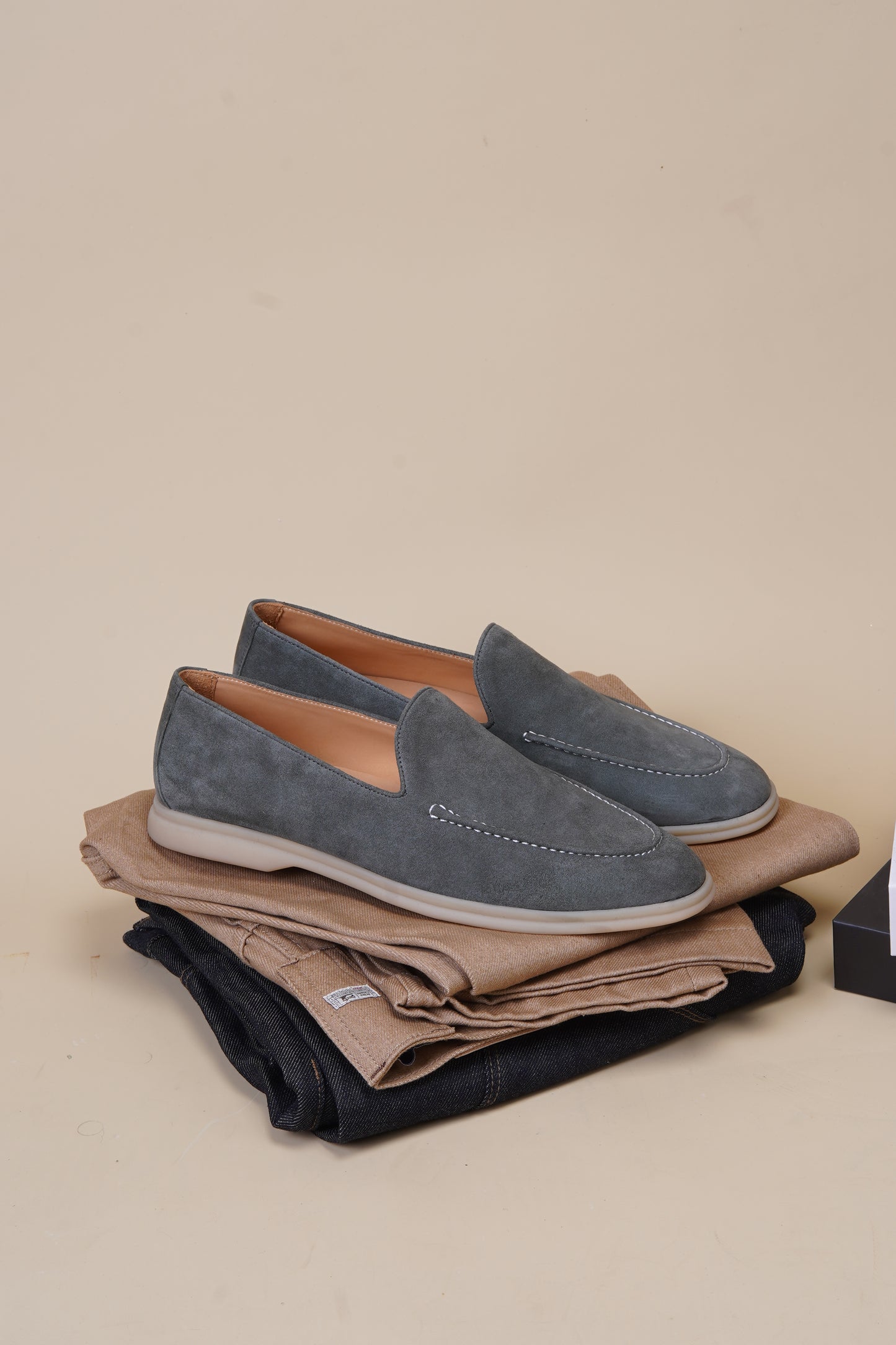 Tuscany sage gray suede loafer shown alongside black and brown colorways on beige background