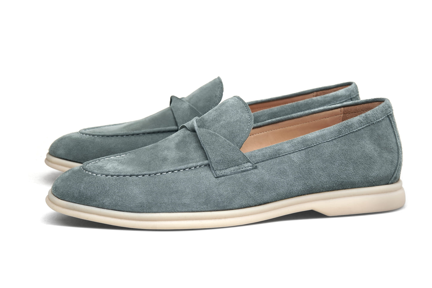 Green suede twist-strap loafers on white background, heel and sole view