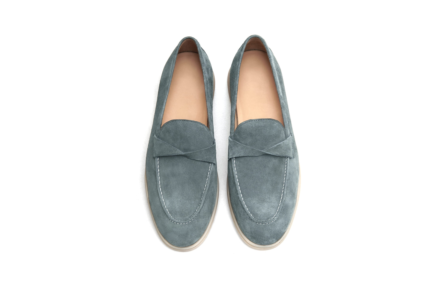 Pair of green suede twist-strap loafers on white background, front view