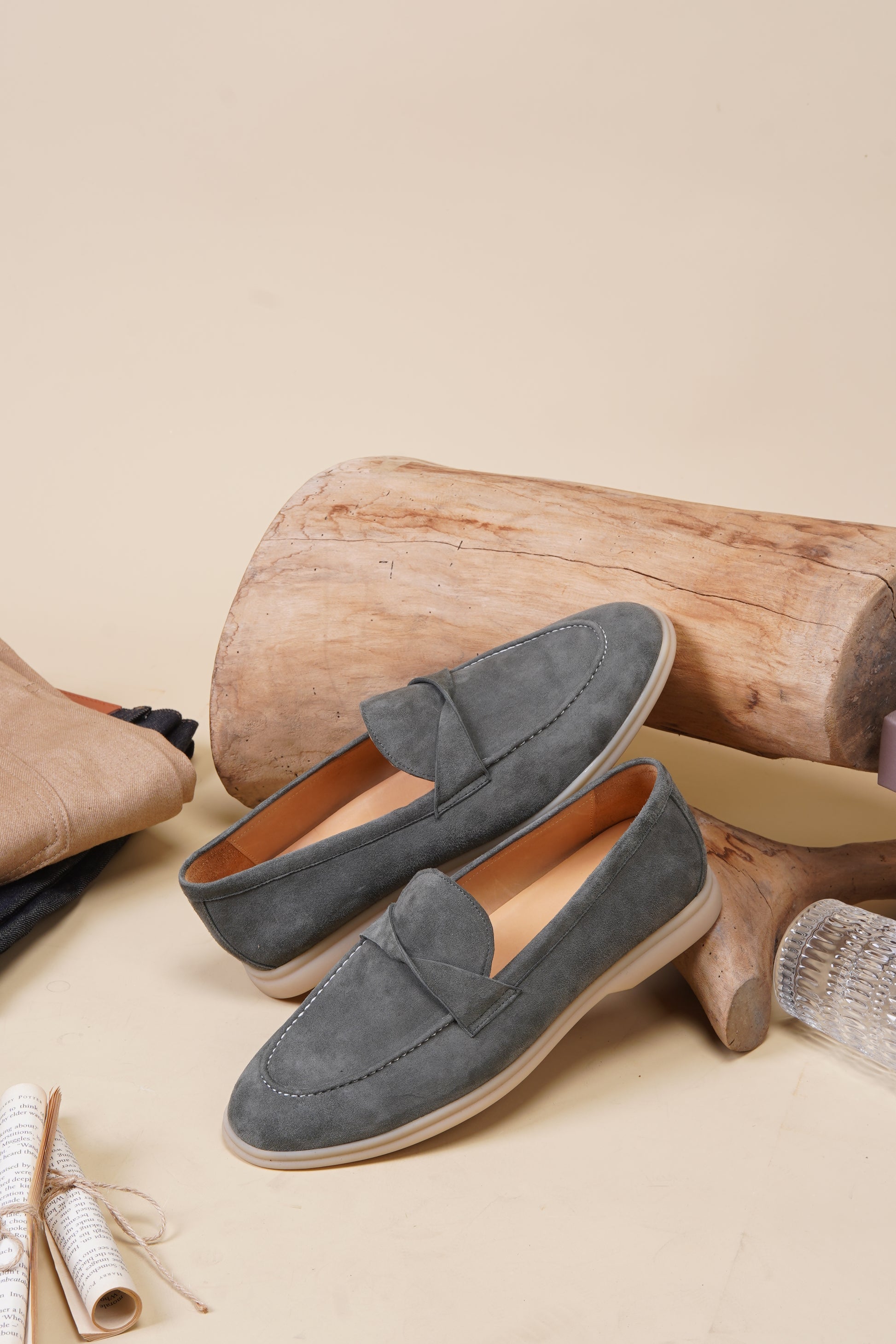 Green suede twist-strap loafers outdoors on grass, side view