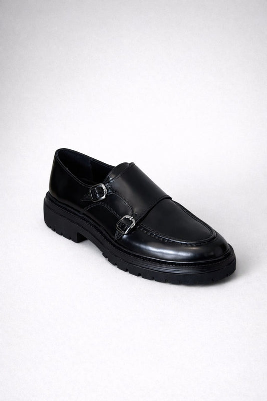 Black leather monk shoe on a white background