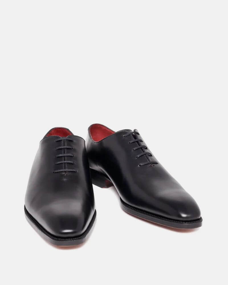 The Nero Noir Polished Black Wholecut Oxford– front angled view showing minimalist design, closed lacing, and red leather interior lining.