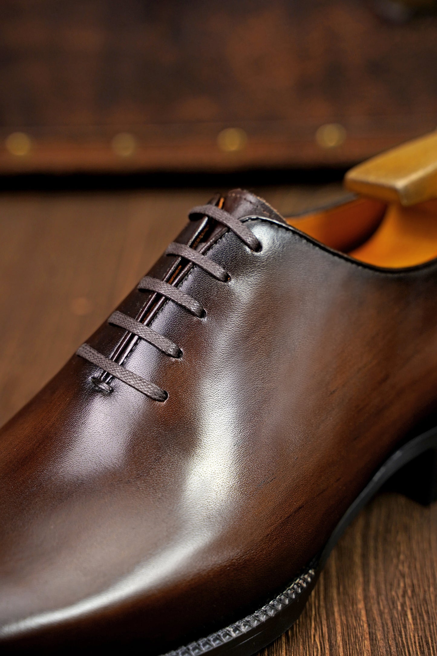 The Regent Cognac Wholecut Oxford – a macro close-up shot focusing on the intricate laces and burnished finish of a single shoe.