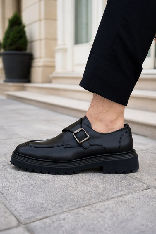 Black leather shoes with a buckle on a stone pavement