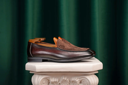 Velvet Crest Brown Leather Suede Loafers – pair with shoe trees on a classical pedestal, highlighting the rich brown leather and elegant design.