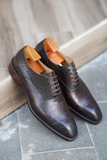 Handcrafted men's dress shoes in genuine crocodile leather on display 