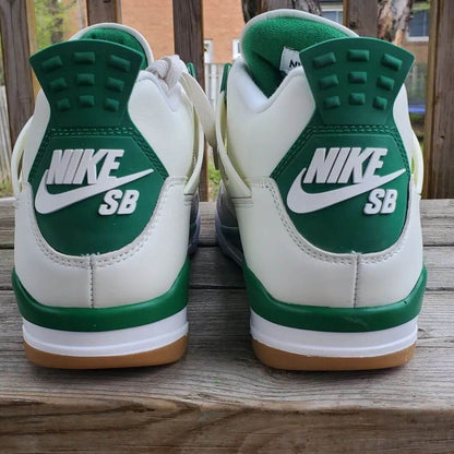 A pair of Air Jordan 4 Retro "Pine Green" sneakers with white leather, grey suede, and pine green accents.