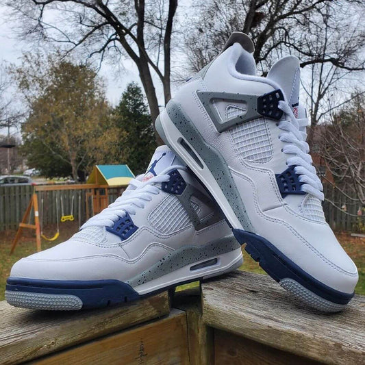 A pair of Air Jordan 4 Retro "Midnight Navy" replica sneakers with a white leather upper, midnight navy accents, and grey speckled detailing.