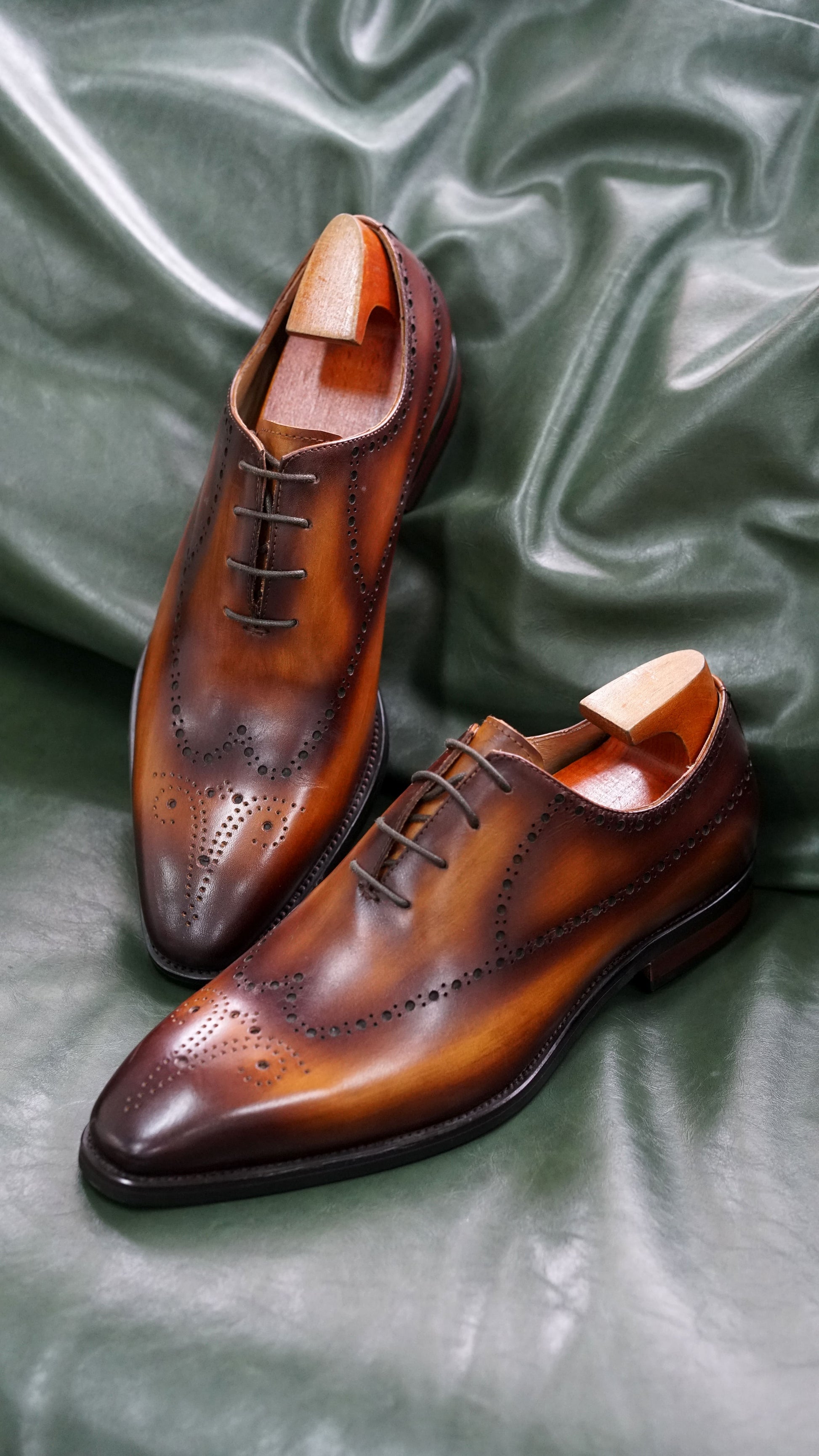 Brown leather Oxford shoes with intricate brogueing and a timeless design