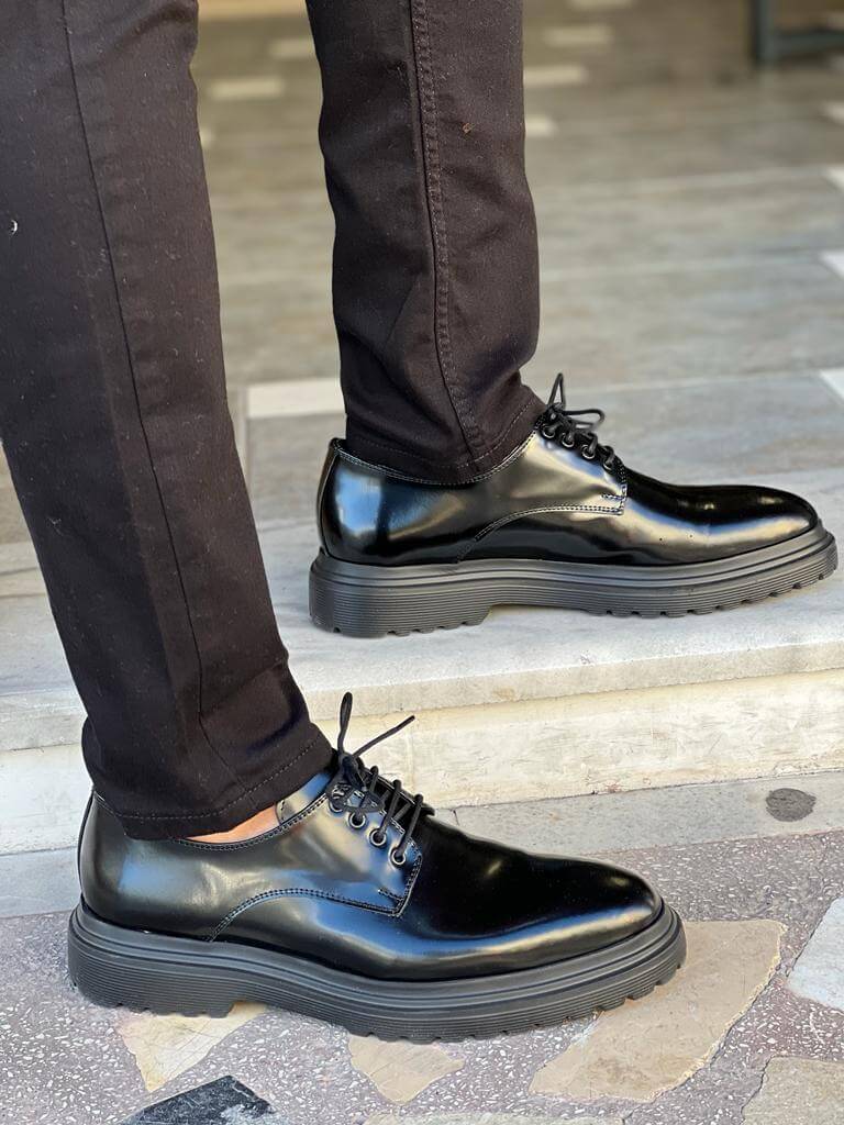 Black Derby Lace-Up Shoes – comfortable polished leather, worn by a man in black trousers, standing on steps, highlighting sleek design for everyday wear.