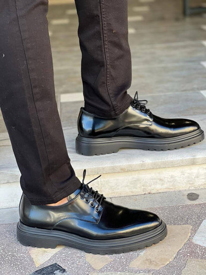 Black Derby Lace-Up Shoes – comfortable polished leather, worn by a man in black trousers, standing on steps, highlighting sleek design for everyday wear.