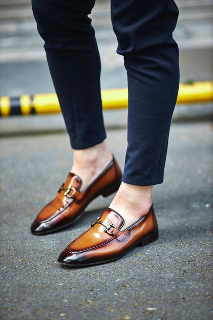 Custer Camel Bit Loafers – Classic Leather Footwear for Every Occasion – worn by a man in dark trousers, highlighting a sleek silhouette, polished finish, and a distinctive horsebit buckle.