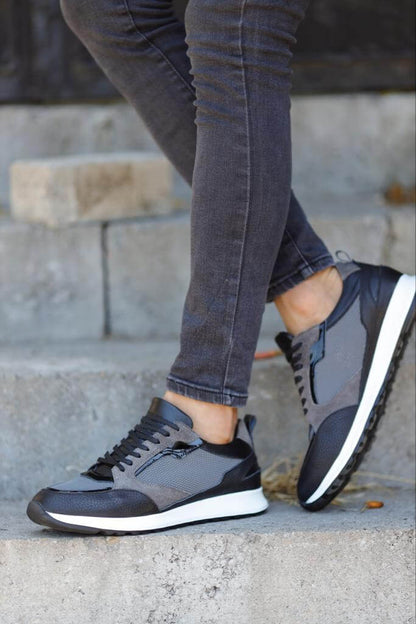 Detailed Gray Sneakers for Casual & Everyday Wear – worn by a man in grey jeans, standing on concrete steps, showcasing sleek design and a comfortable fit.