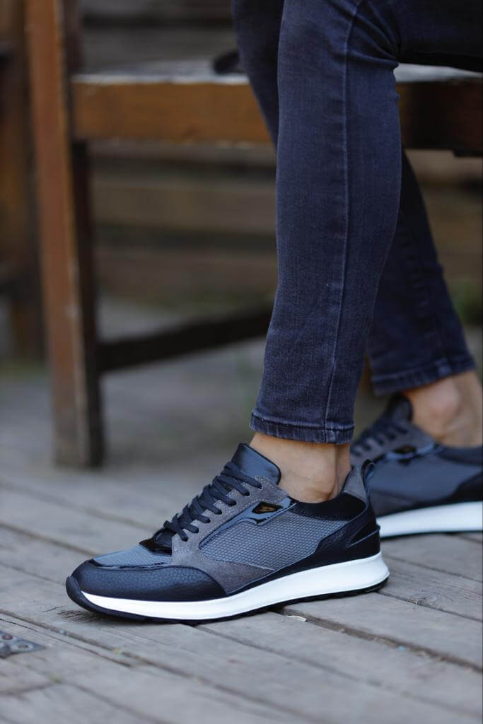 Detailed Gray Sneakers for Casual & Everyday Wear – worn by a man in black jeans, standing on a wooden floor, highlighting unique detailing and a comfortable EVA sole.