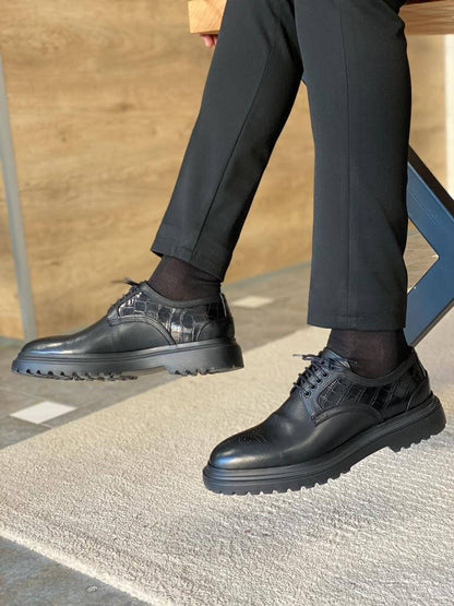 Handcrafted Black Leather Derby Shoes – polished leather and textured detail, worn by a man adjusting black trousers, showcasing classic and modern craftsmanship.