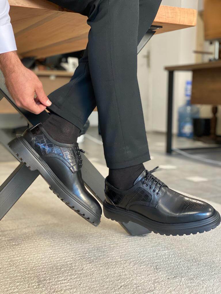 Handcrafted Black Leather Derby Shoes – sleek black leather, worn by a man in black trousers with one foot lifted, highlighting the EVA sole and versatile style.