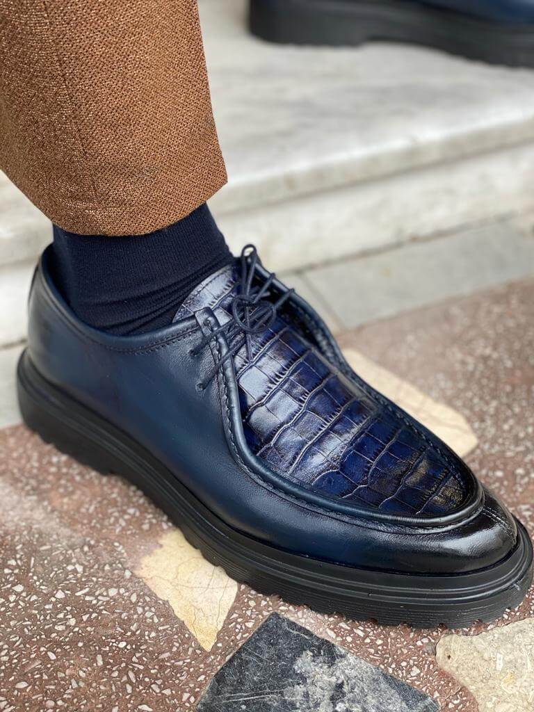 Dark Blue Crocodile Leather Derby Shoes – close-up on foot, worn by a man in brown trousers, emphasizing the distinctive crocodile-embossed pattern.