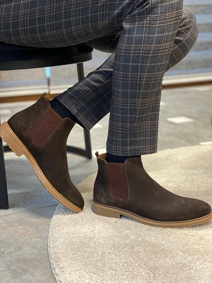 Handmade Brown Suede Leather Chelsea Boots – a man posing with one foot on a table, showcasing the durable EVA sole and the boot's profile.