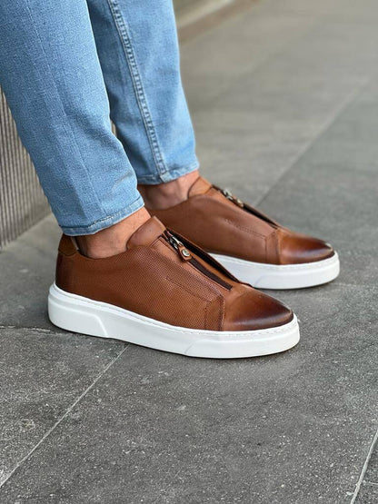 HolloShoe Brown Mid-Top Zipper Slip-Ons for Men – worn by a man in blue jeans, leaning against a wall, highlighting a modern touch and a versatile look.