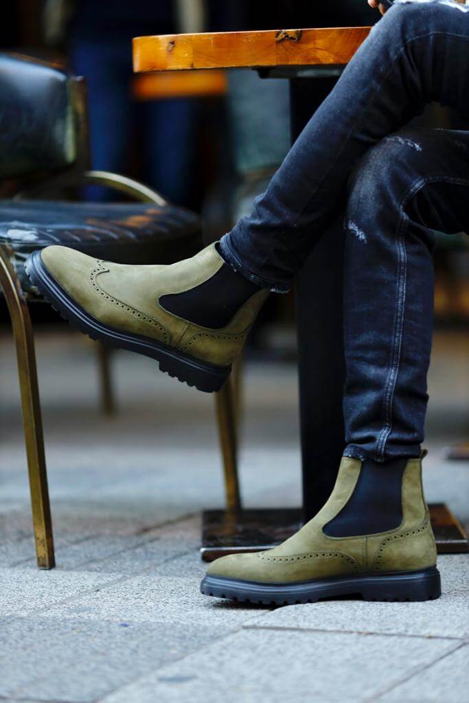 HolloShoe Khaki Nubuck Wingtip Chelsea Boots for All-Day Comfort – a man wearing the boots and sitting at an outdoor table, showing a full-side view of the shoe.