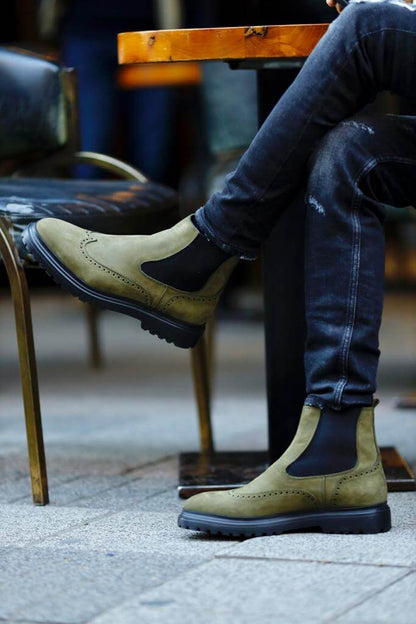 HolloShoe Khaki Nubuck Wingtip Chelsea Boots for All-Day Comfort – a man wearing the boots and sitting at an outdoor table, showing a full-side view of the shoe.