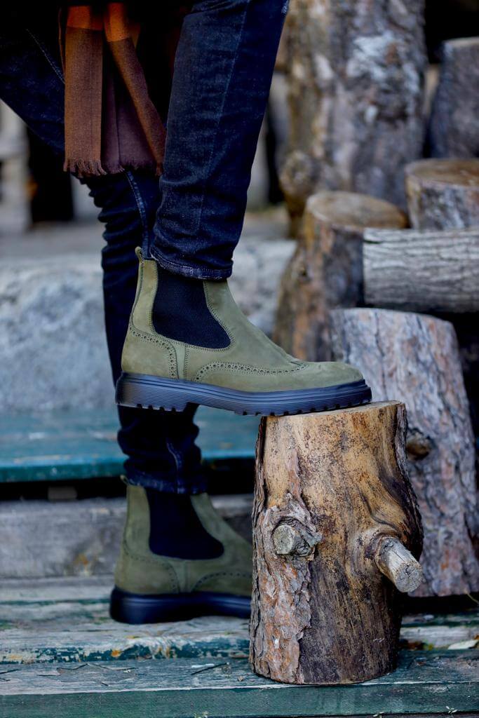 HolloShoe Khaki Nubuck Wingtip Chelsea Boots for All-Day Comfort – a man sitting in a chair, with a close-up on the boots to highlight the wingtip detail.
