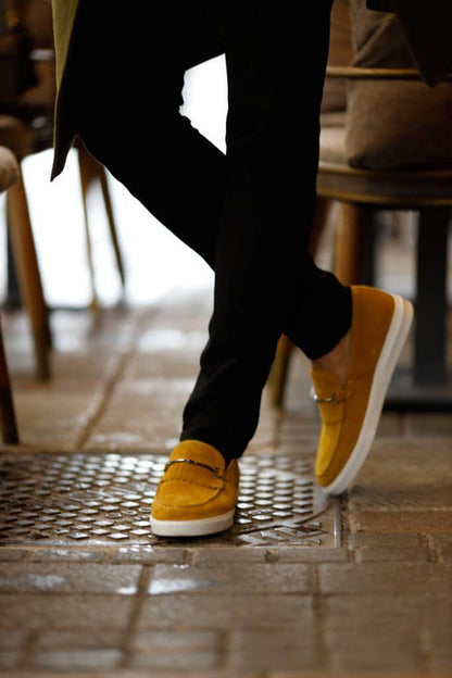 HolloShoe Special Edition Iron Detailed Yellow Slip-Ons – worn by a man in black trousers, standing, highlighting a sleek silhouette and a confident, modern look.
