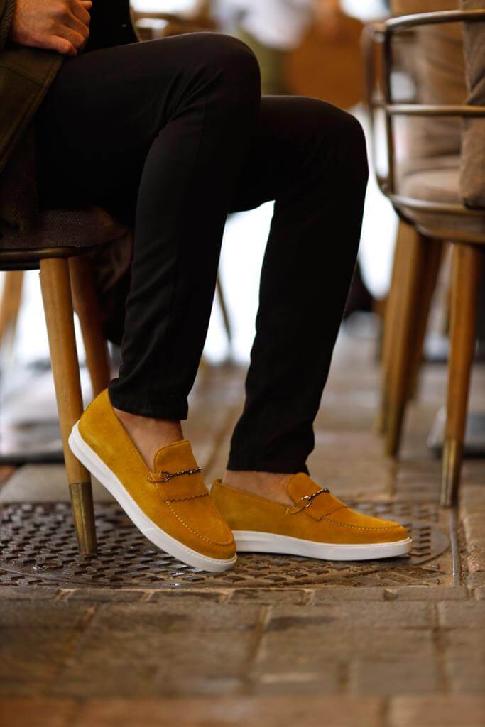 HolloShoe Special Edition Iron Detailed Yellow Slip-Ons – worn by a man in black trousers, sitting in a chair, highlighting a sleek and sophisticated style.