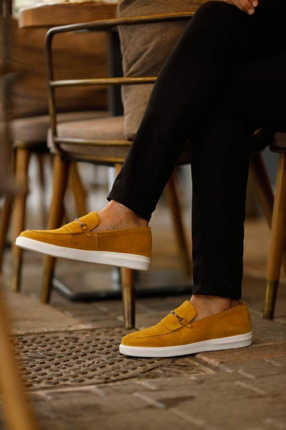 HolloShoe Special Edition Iron Detailed Yellow Slip-Ons – worn by a man in black trousers, with one foot elevated, highlighting a comfortable and supportive fit.