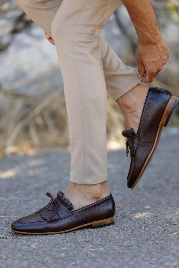 Brown penny loafers with penny slot detail.