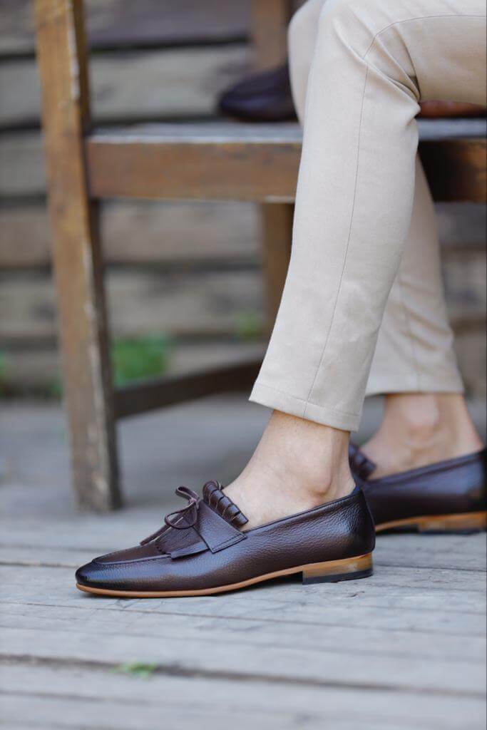 Brown penny loafers with penny slot detail.