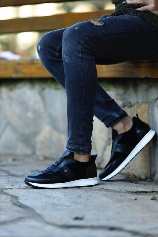 Modern Black Suede Leather Sneakers – worn by a man in black jeans, with one foot elevated, highlighting the durable EVA sole and sleek silhouette.