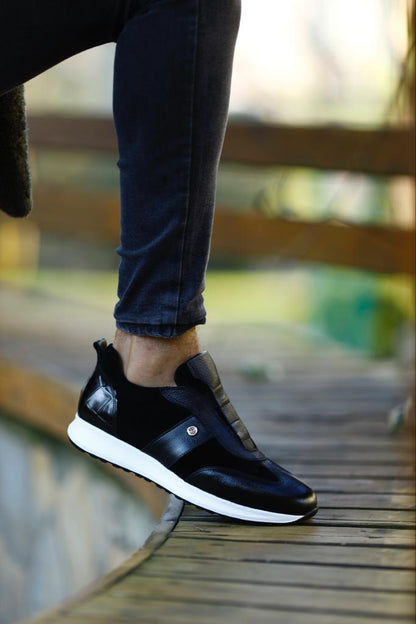 Modern Black Suede Leather Sneakers – worn by a man in black jeans, with one foot elevated, highlighting the durable EVA sole and sleek silhouette.