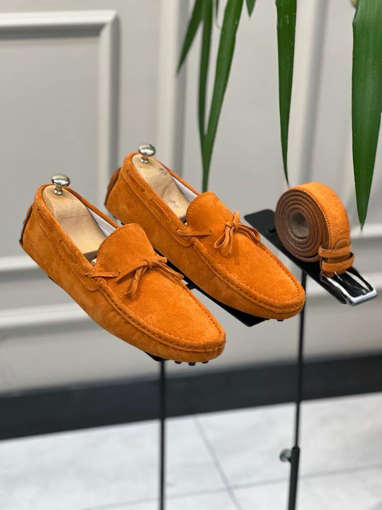 Premium Oakmond Orange Suede Driving Loafers – pair displayed on a stand, with a matching belt, showcasing a luxurious touch and comfortable fit.