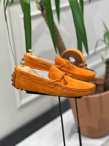 Premium Oakmond Orange Suede Driving Loafers – pair displayed on a stand, with a matching belt, highlighting a luxurious touch and comfortable fit.