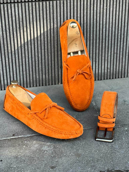 Premium Oakmond Orange Suede Driving Loafers – pair with a matching belt on a grey concrete floor, highlighting high-quality suede and an elegant design.